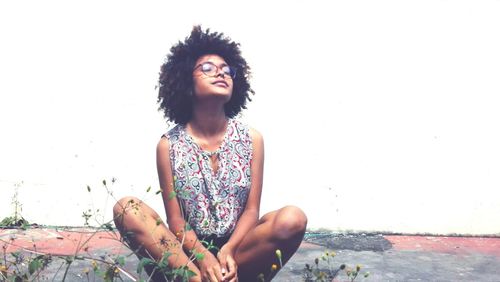 Young woman looking at camera against sky