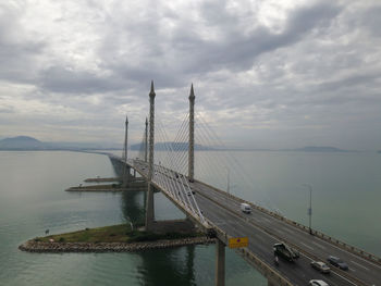 Suspension bridge over sea against sky