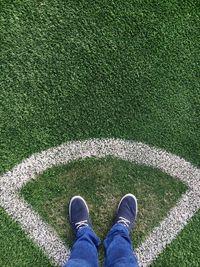 Low section of man standing on grass