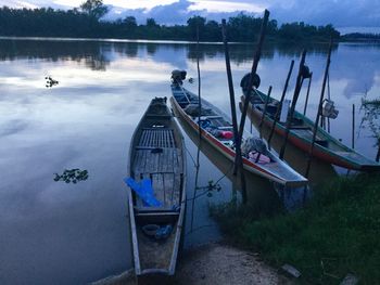 Boats moored on lake against sky