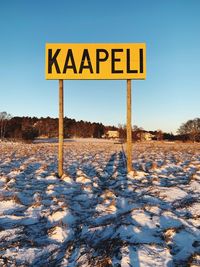 Road sign on snow covered field