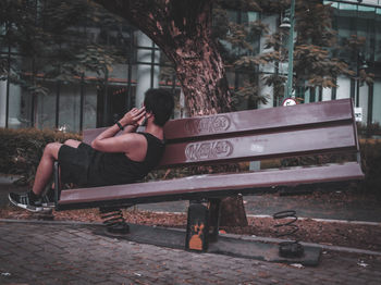 Man sitting on bench against trees