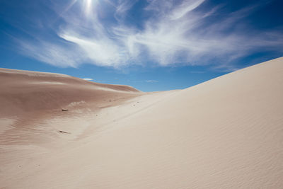 Sand dunes in desert against sky