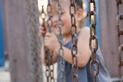 Close-up of girl standing on play equipment at park