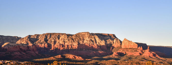 Low angle view of rock formations against clear blue sky