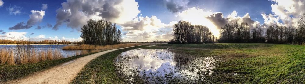 Scenic view of river against cloudy sky