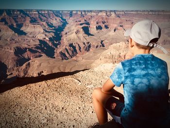 Rear view of boy sitting at grand canyon national park 