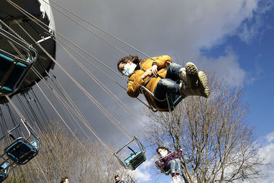 Low angle view of chain swing ride against sky