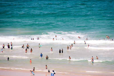 Crowd at beach against sky