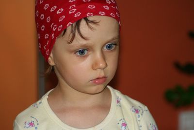 Close-up of thoughtful girl wearing bandana standing at home