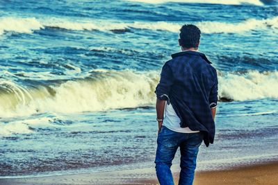 Rear view of man standing at beach