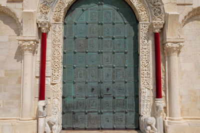 Closed arch door of church on sunny day