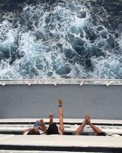 Directly above shot of friends on ferry sailing in sea