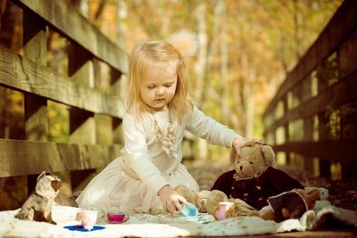 Cute girl playing with toys on boardwalk