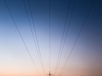 Low angle view of cables against clear sky during dusk