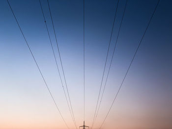 Low angle view of electricity pylon against clear sky