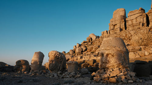 Low angle view of rock formations against clear blue sky