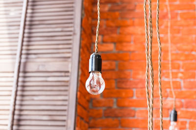 Close-up of electric lamp hanging on wall