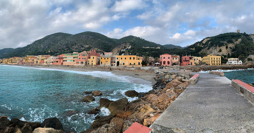 Scenic view of sea by buildings against sky