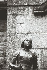 Portrait of man standing against brick wall