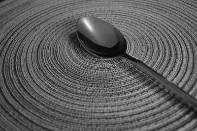 Close-up of spoon on woven circular patter