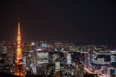 Illuminated buildings in city against sky at night