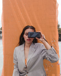 Young woman photographing camera