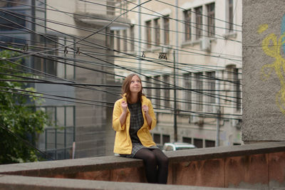 Young woman sitting on railing