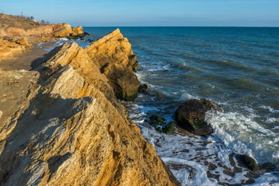 Scenic view of rocks in sea against sky