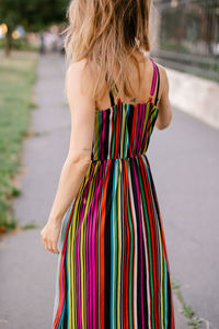 Rear view of woman standing against trees