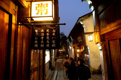 People walking on illuminated building at night