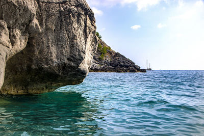 Rock formation in sea against sky