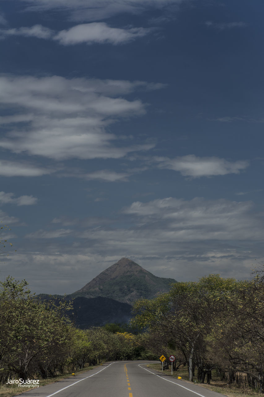 cloud - sky, road, transportation, sky, sign, scenics - nature, mountain, day, nature, the way forward, direction, no people, beauty in nature, plant, tree, non-urban scene, vanishing point, diminishing perspective, symbol, outdoors, long