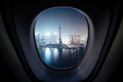 Buildings against sky seen through airplane window