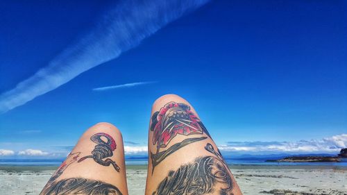 Low section of woman relaxing on beach