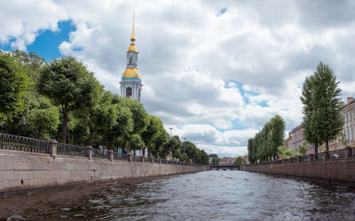 Panoramic view of river amidst trees and buildings against sky