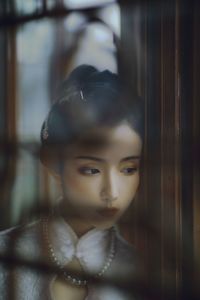 Portrait of a girl looking through window