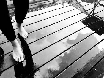 Low section of woman walking on wet pier