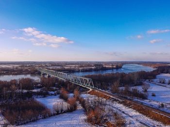 Winter landscape of a railway viaduct across the vistula river with a blue cloudless sky 