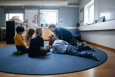 Teacher playing with children on floor at school