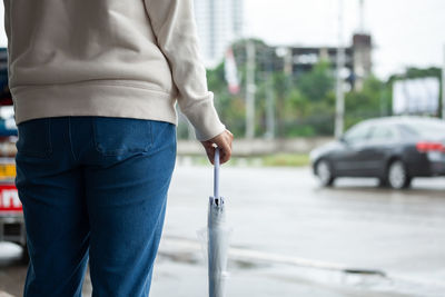 Midsection of woman standing on street