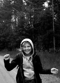 Portrait of girl smiling while standing against trees