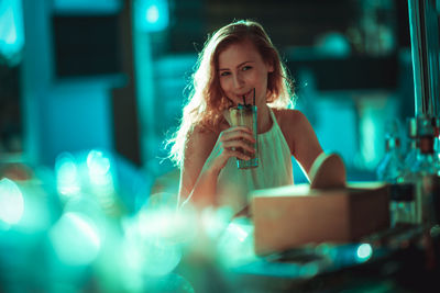 Young woman having drink at sidewalk cafe