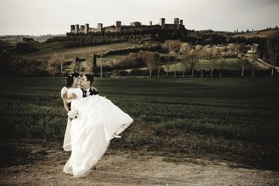 Rear view of couple kissing on field