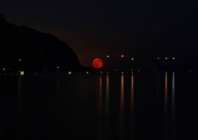 Scenic view of river against sky at night