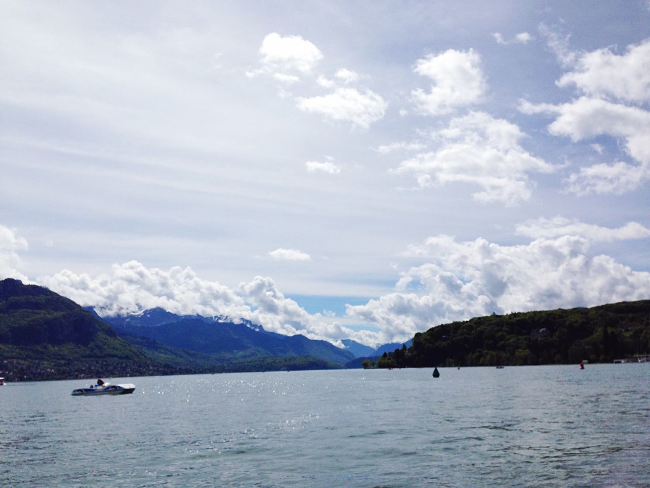 water, mountain, sky, waterfront, tranquil scene, scenics, transportation, nautical vessel, tranquility, beauty in nature, sea, mountain range, cloud - sky, boat, mode of transport, nature, cloud, cloudy, lake, river