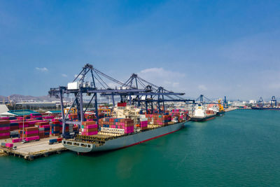 Commercial dock and cranes with shipping containers at harbor 