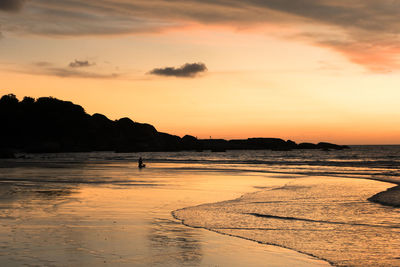 Scenic view of beach against sky during sunset