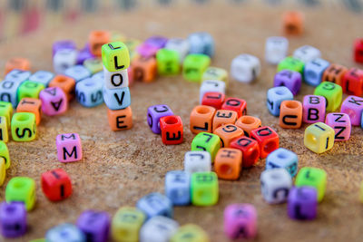 Close-up of multi colored beads with alphabets on table