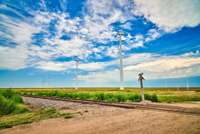 Railroad tracks on field against sky